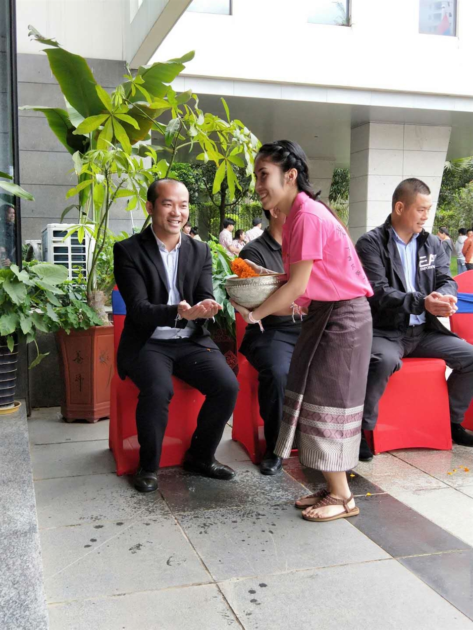 老撾駐廣西留學(xué)生代表將浸有花瓣的香水灑客人的手上，表示對嘉賓的美好祝福（圖一）