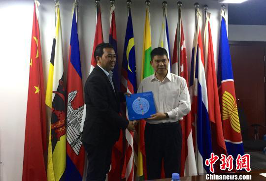 中國—東盟博覽會秘書處副秘書長黃平西（右）與柬埔寨新聞部新聞與傳播總司副總司長春占皮侖（左）互贈禮物。