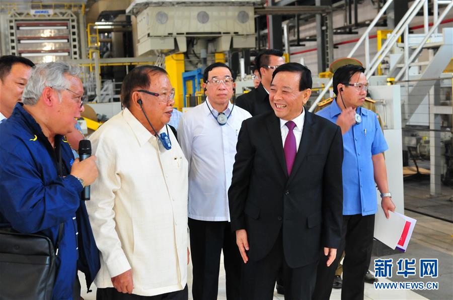3月10日，在老撾沙灣拿吉省車邦縣，老撾人民革命黨中央總書記、國家主席本揚(yáng)（左二）在山東太陽紙業(yè)股份有限公司董事長李洪信（右二）的陪同下視察公司。 新華社記者章建華攝